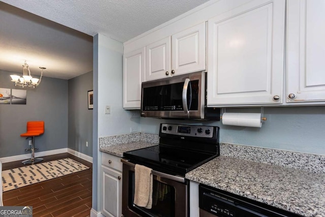 375 Ralph Mcgill Blvd NE Unit 1701, Atlanta, GA 30312 - kitchen featuring appliances with stainless steel finishes, white cabinetry, dark wood-style flooring, a chandelier, and light stone counters