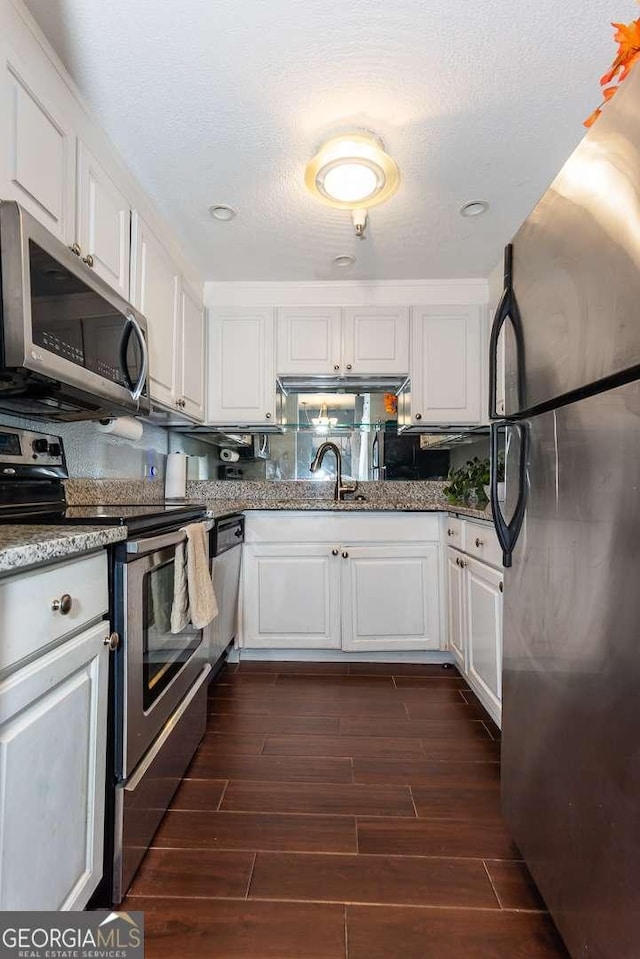 375 Ralph Mcgill Blvd NE Unit 1701, Atlanta, GA 30312 - kitchen with stainless steel appliances, white cabinetry, dark wood finished floors, and stone counters
