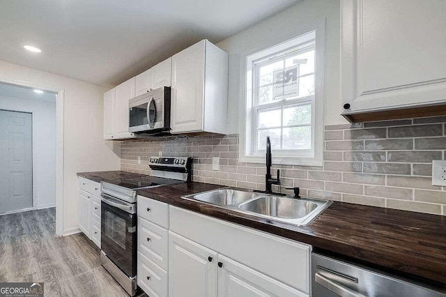 5215 Cordell St, Savannah, GA 31405 - kitchen featuring appliances with stainless steel finishes, white cabinetry, and decorative backsplash