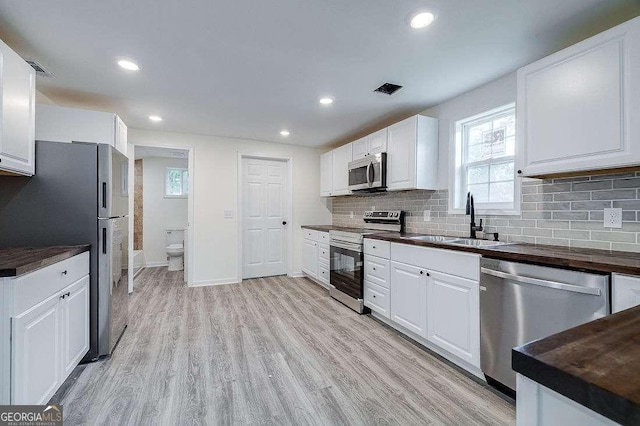 5215 Cordell St, Savannah, GA 31405 - kitchen featuring stainless steel appliances, healthy amount of natural light, backsplash, white cabinets, and recessed lighting