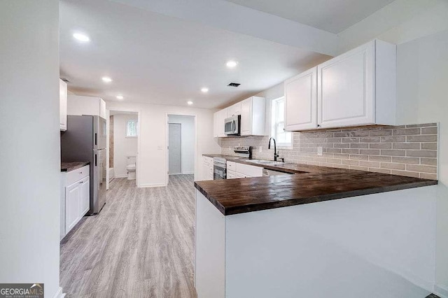 5215 Cordell St, Savannah, GA 31405 - kitchen featuring stainless steel appliances, dark countertops, backsplash, light wood finished floors, and recessed lighting