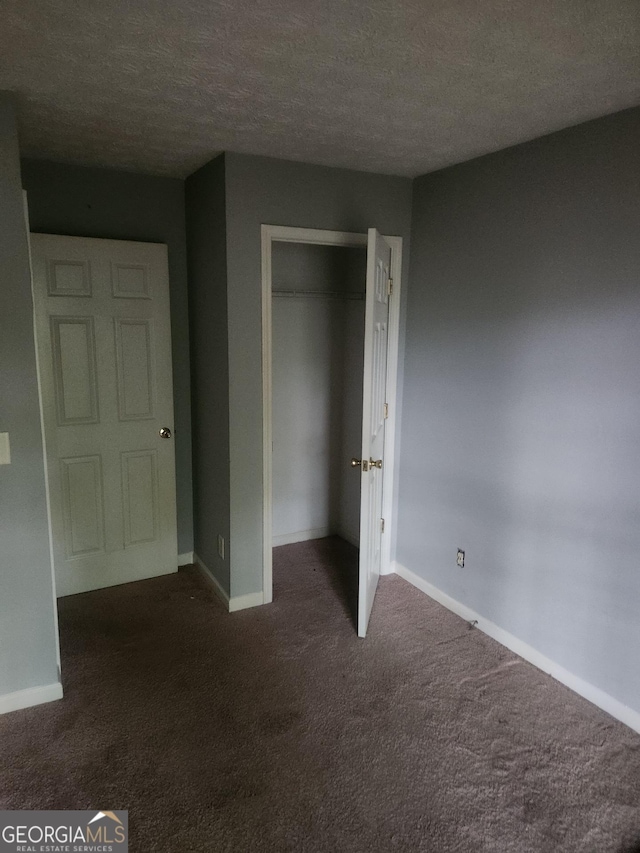 2756 Norfair Loop, Lithonia, GA 30038 - unfurnished bedroom featuring dark colored carpet, a textured ceiling, and a closet
