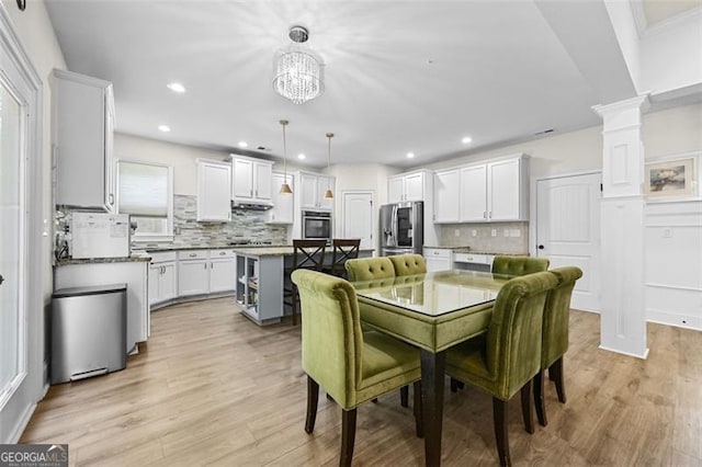 5825 Trailwood Ct, Suwanee, GA 30024 - dining space with decorative columns, light wood finished floors, a chandelier, and recessed lighting