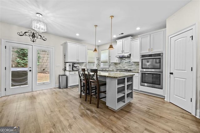 5825 Trailwood Ct, Suwanee, GA 30024 - kitchen with appliances with stainless steel finishes, under cabinet range hood, light wood-style floors, plenty of natural light, and recessed lighting
