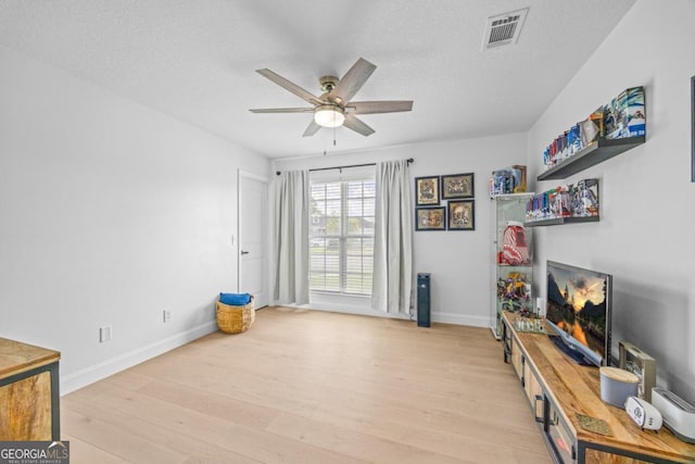 513 Cascade Ct, Hinesville, GA 31313 - living area featuring light wood finished floors, ceiling fan, and a textured ceiling