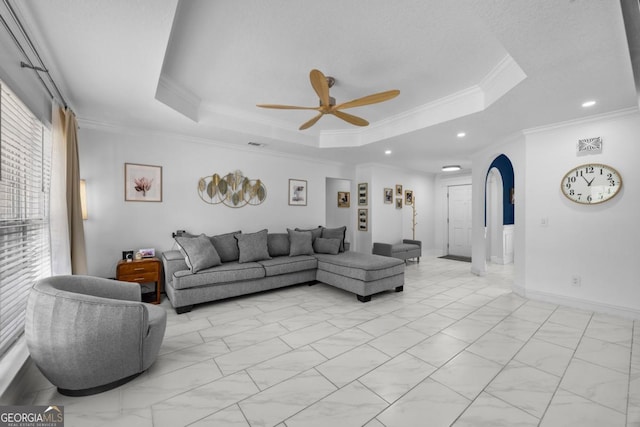 513 Cascade Ct, Hinesville, GA 31313 - living area featuring a tray ceiling, ceiling fan, crown molding, light marble finish flooring, and arched walkways