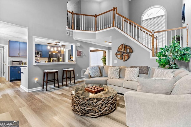 3229 Dunlin Lake Rd, Lawrenceville, GA 30044 - living area with light wood-type flooring, a high ceiling, healthy amount of natural light, and stairs
