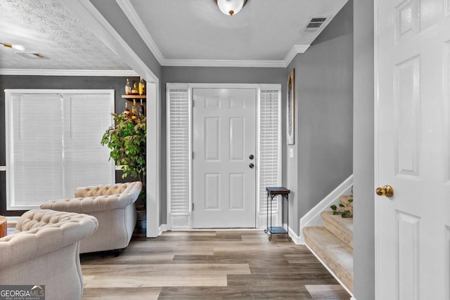 3229 Dunlin Lake Rd, Lawrenceville, GA 30044 - foyer entrance featuring wood finished floors, stairway, ornamental molding, and a textured ceiling
