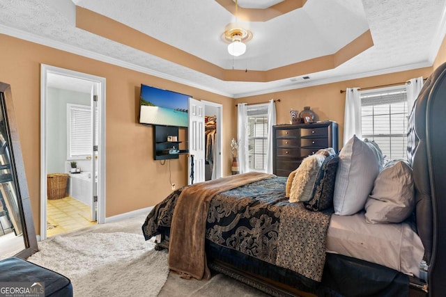 3229 Dunlin Lake Rd, Lawrenceville, GA 30044 - carpeted bedroom featuring a tray ceiling, multiple windows, crown molding, connected bathroom, and a spacious closet