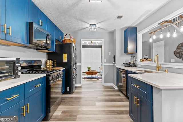 3229 Dunlin Lake Rd, Lawrenceville, GA 30044 - kitchen with appliances with stainless steel finishes, blue cabinetry, light wood-style floors, a textured ceiling, and light stone countertops