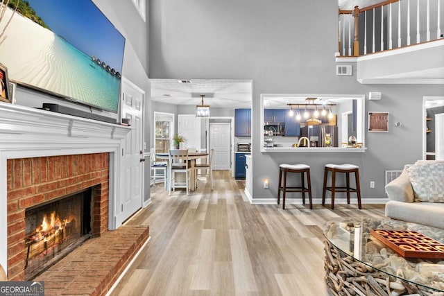 3229 Dunlin Lake Rd, Lawrenceville, GA 30044 - living area featuring a towering ceiling, a fireplace, and wood finished floors