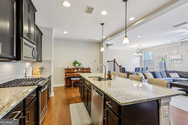 8215 Harlond Way, Suwanee, GA 30024 - kitchen featuring appliances with stainless steel finishes, open floor plan, tasteful backsplash, recessed lighting, and dark wood-style flooring