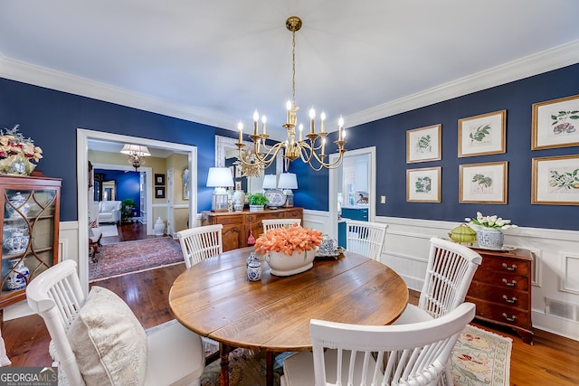6180 Old Jefferson Rd, Athens, GA 30607 - dining area featuring a chandelier, wood finished floors, crown molding, a wainscoted wall, and a decorative wall
