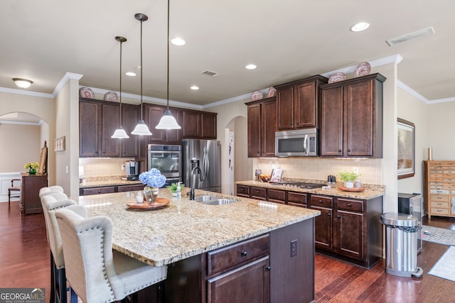 1626 Waterchase Dr, Dacula, GA 30019 - kitchen with arched walkways, appliances with stainless steel finishes, crown molding, dark brown cabinetry, and dark wood finished floors