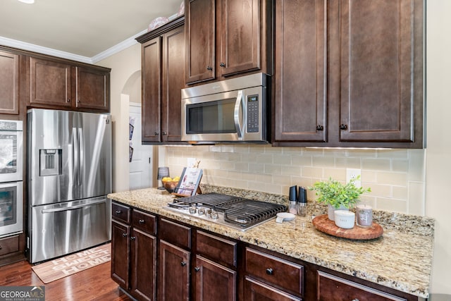 1626 Waterchase Dr, Dacula, GA 30019 - kitchen with appliances with stainless steel finishes, crown molding, dark brown cabinets, arched walkways, and dark wood-style floors