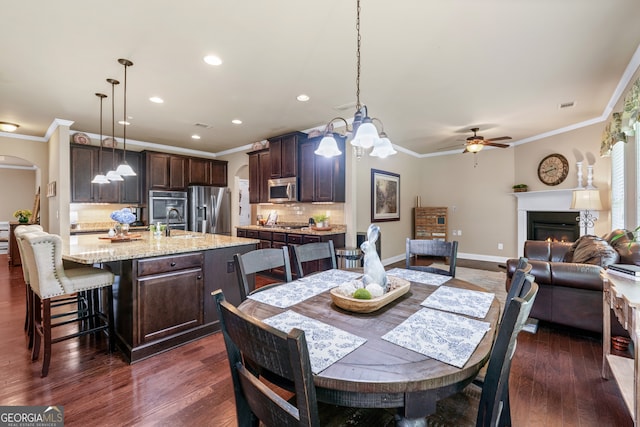 1626 Waterchase Dr, Dacula, GA 30019 - dining room with ornamental molding, a ceiling fan, dark wood-style flooring, recessed lighting, and a glass covered fireplace