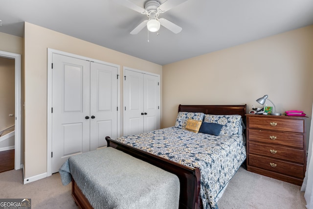 1626 Waterchase Dr, Dacula, GA 30019 - bedroom with multiple closets, light colored carpet, and a ceiling fan