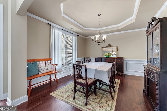 1626 Waterchase Dr, Dacula, GA 30019 - dining area featuring a raised ceiling, dark wood-style flooring, a chandelier, a wainscoted wall, and ornamental molding