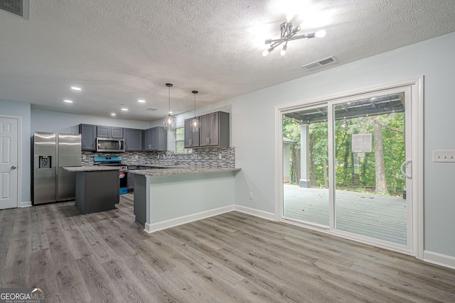 4959 Abbotts Glen Trl NW, Acworth, GA 30101 - kitchen with stainless steel appliances, light wood-style flooring, gray cabinetry, a textured ceiling, and backsplash