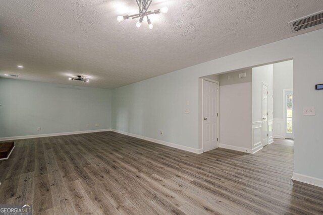 4959 Abbotts Glen Trl NW, Acworth, GA 30101 - spare room featuring dark wood-style flooring, a textured ceiling, and a chandelier