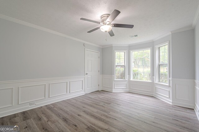 4959 Abbotts Glen Trl NW, Acworth, GA 30101 - empty room with wood finished floors, ceiling fan, a textured ceiling, wainscoting, and a decorative wall