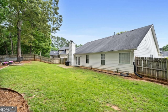 192 Sandhurst Ct, Suwanee, GA 30024 - back of property with a fenced backyard, roof with shingles, and a chimney