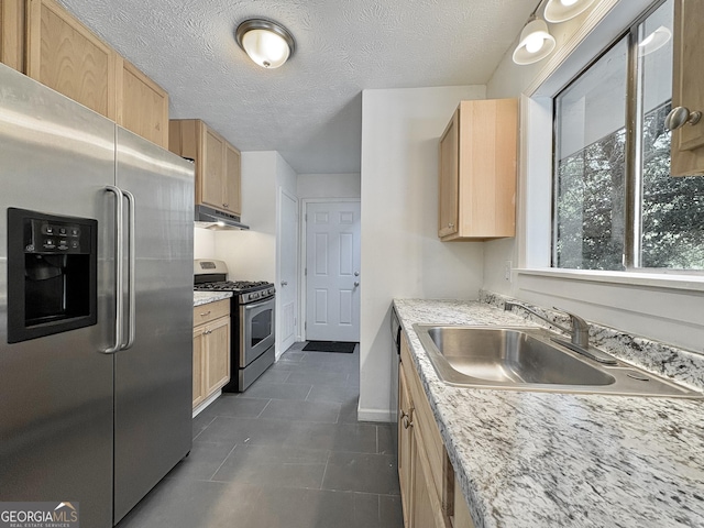 10173 Brass Ring Rd, Jonesboro, GA 30238 - kitchen featuring appliances with stainless steel finishes, light brown cabinetry, under cabinet range hood, dark tile patterned floors, and a textured ceiling