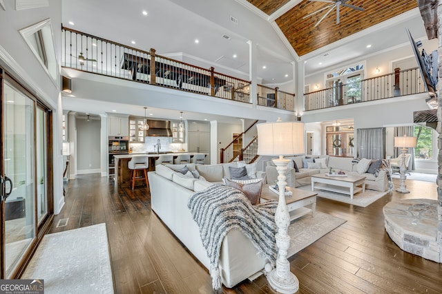 6590 Lights Ferry Rd, Flowery Branch, GA 30542 - living room featuring high vaulted ceiling, dark wood-style floors, stairway, and crown molding