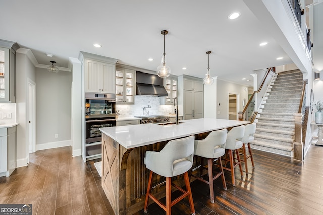 6590 Lights Ferry Rd, Flowery Branch, GA 30542 - kitchen with wall chimney exhaust hood, stainless steel double oven, ornamental molding, backsplash, and light countertops