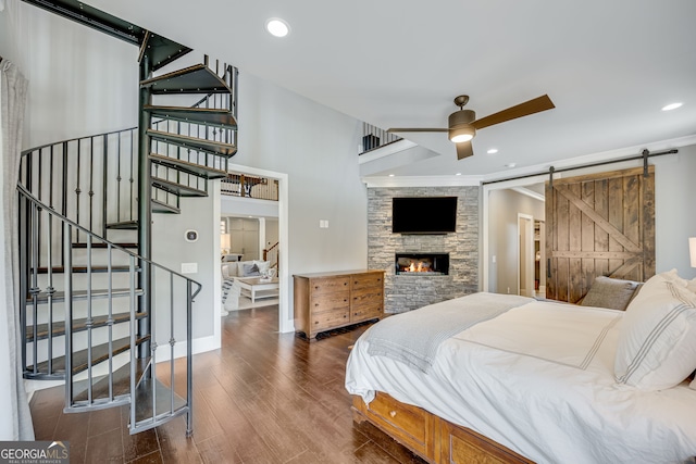 6590 Lights Ferry Rd, Flowery Branch, GA 30542 - bedroom featuring wood finished floors, recessed lighting, a barn door, and a fireplace