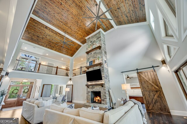 6590 Lights Ferry Rd, Flowery Branch, GA 30542 - living room featuring high vaulted ceiling, a fireplace, ceiling fan, hardwood / wood-style floors, and a barn door