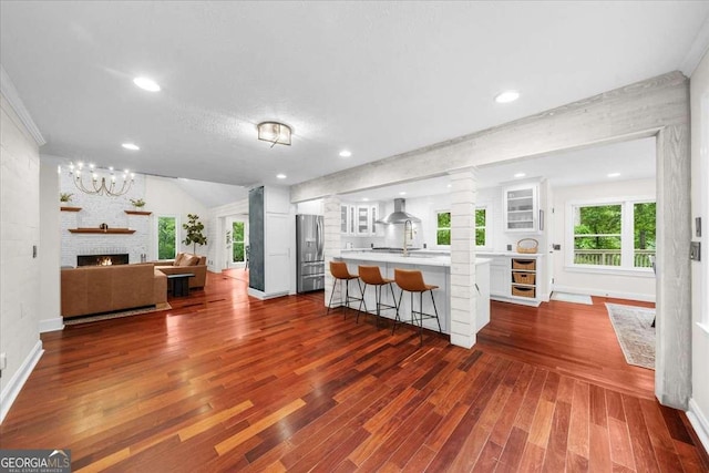 4735 Log Cabin Rd, Gainesville, GA 30504 - kitchen featuring stainless steel refrigerator with ice dispenser, white cabinetry, wall chimney exhaust hood, light countertops, and a breakfast bar