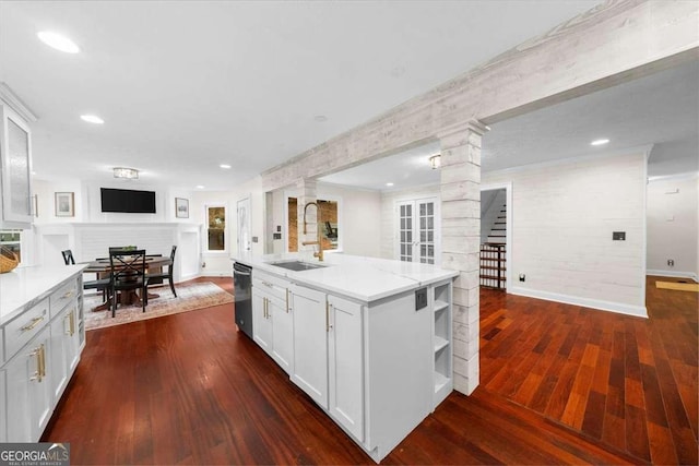 4735 Log Cabin Rd, Gainesville, GA 30504 - kitchen featuring decorative columns, dishwashing machine, open shelves, a fireplace, and dark wood-style flooring