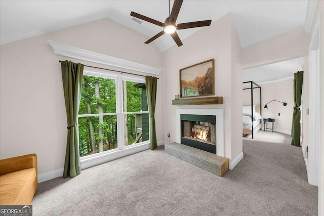 4735 Log Cabin Rd, Gainesville, GA 30504 - unfurnished living room featuring a ceiling fan, carpet, vaulted ceiling, and a warm lit fireplace