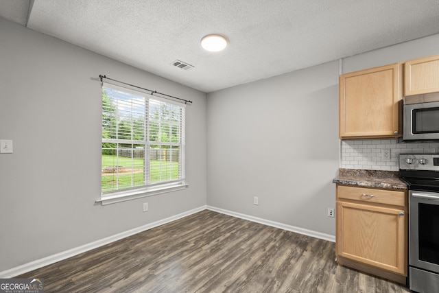 615 Coan Dr, Locust Grove, GA 30248 - kitchen with stainless steel appliances, light brown cabinets, dark countertops, dark wood-type flooring, and tasteful backsplash