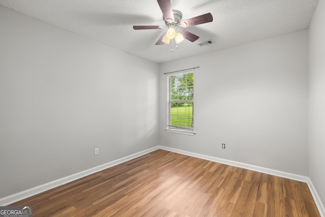 615 Coan Dr, Locust Grove, GA 30248 - unfurnished room with wood finished floors, a ceiling fan, and a textured ceiling