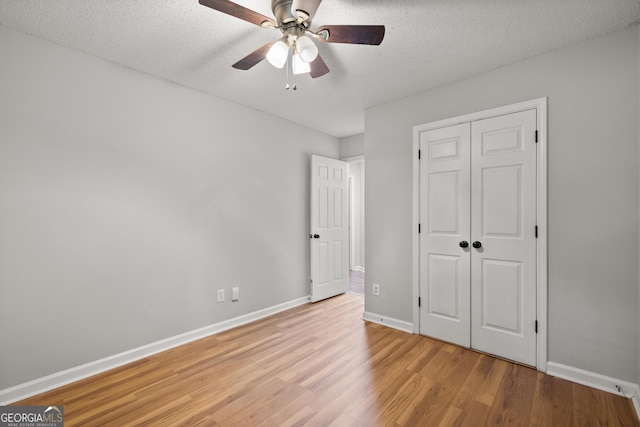 615 Coan Dr, Locust Grove, GA 30248 - unfurnished bedroom featuring light wood-type flooring, a textured ceiling, a closet, and ceiling fan