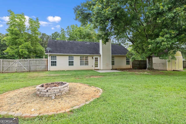 615 Coan Dr, Locust Grove, GA 30248 - back of property with a patio area, an outdoor fire pit, a storage unit, a chimney, and a fenced backyard