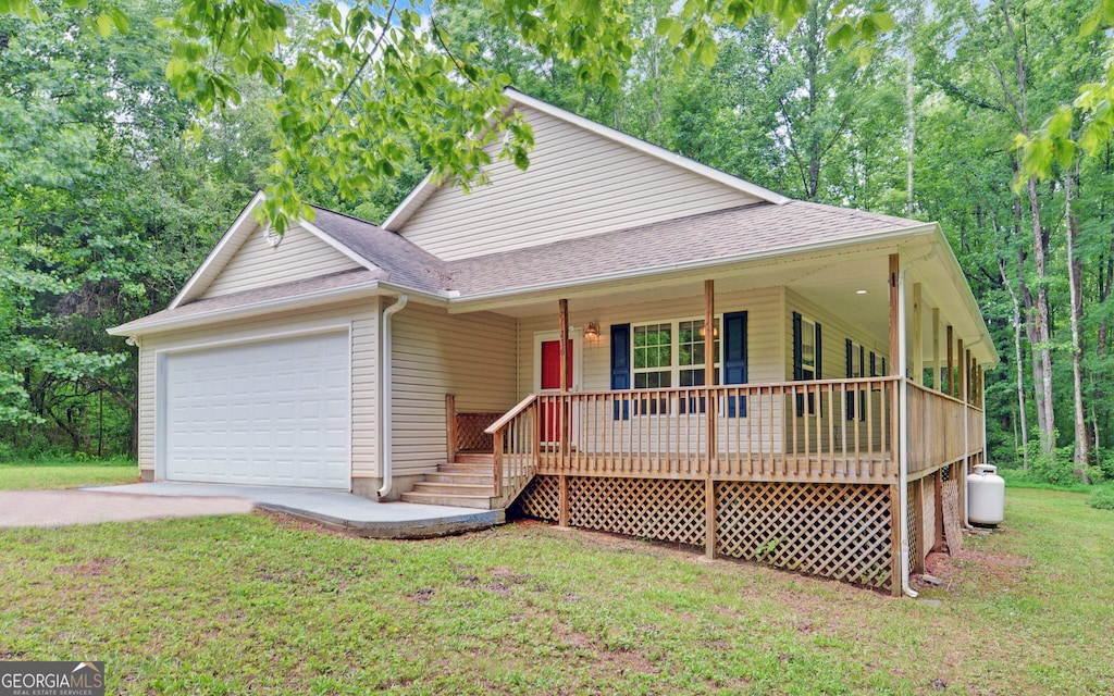 235 Irvin Lake Rd, Mount Airy, GA 30563 - view of front of home with an attached garage, a porch, a front lawn, roof with shingles, and driveway