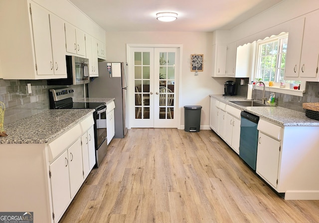 723 Fricks Ln, Rossville, GA 30741 - kitchen with appliances with stainless steel finishes, french doors, backsplash, light wood-type flooring, and white cabinetry