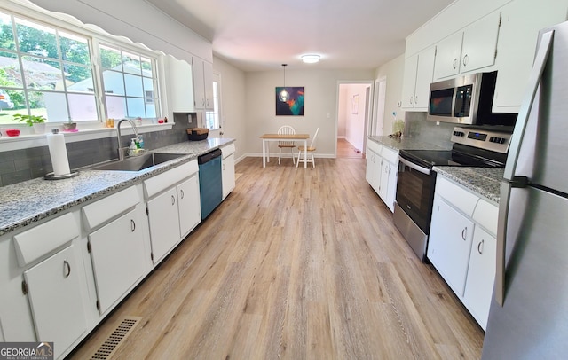 723 Fricks Ln, Rossville, GA 30741 - kitchen with appliances with stainless steel finishes, tasteful backsplash, light wood-style flooring, and white cabinets
