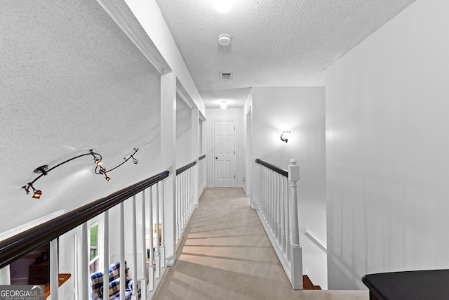 100 Merrill Dr, Lagrange, GA 30241 - hallway featuring a textured ceiling, an upstairs landing, and light colored carpet