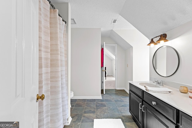 100 Merrill Dr, Lagrange, GA 30241 - bathroom with a textured ceiling, vanity, stone finish floors, and vaulted ceiling