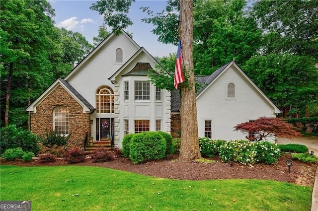 525 Avala Ct, Johns Creek, GA 30022 - view of front facade featuring stucco siding, a front yard, and stone siding