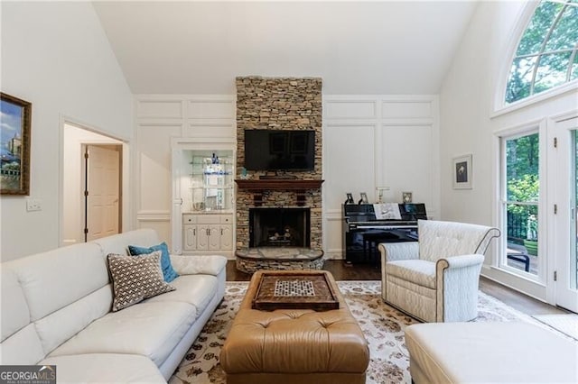 525 Avala Ct, Johns Creek, GA 30022 - living area with a decorative wall, a fireplace, wood finished floors, and high vaulted ceiling
