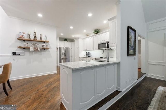 525 Avala Ct, Johns Creek, GA 30022 - kitchen featuring stainless steel appliances, a peninsula, dark wood finished floors, light stone counters, and recessed lighting