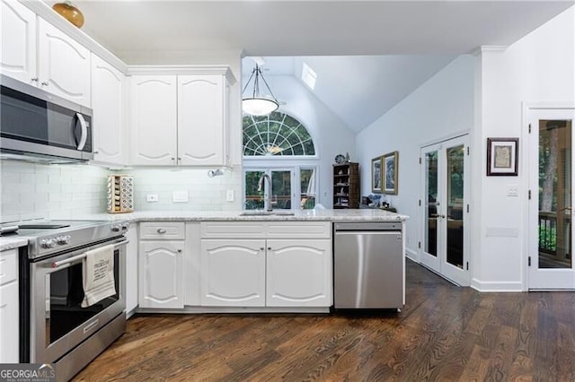 525 Avala Ct, Johns Creek, GA 30022 - kitchen with appliances with stainless steel finishes, vaulted ceiling, white cabinets, decorative backsplash, and dark wood finished floors