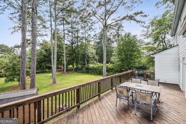 3220 Casteel Rd, Marietta, GA 30062 - wooden deck featuring outdoor dining space, a lawn, and view of wooded area