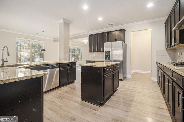 7691 Brazos Trl, Fairburn, GA 30213 - kitchen featuring stainless steel appliances, a kitchen island, backsplash, ornamental molding, and light wood-style flooring