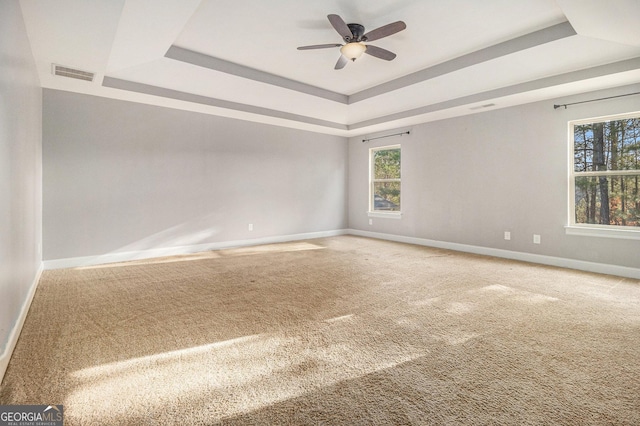 7691 Brazos Trl, Fairburn, GA 30213 - carpeted spare room featuring a tray ceiling, plenty of natural light, and a ceiling fan